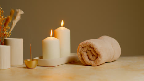 Still-Life-Of-Lit-Candles-With-Dried-Grasses-Incense-Stick-And-Soft-Towels-As-Part-Of-Relaxing-Spa-Day-Decor-4